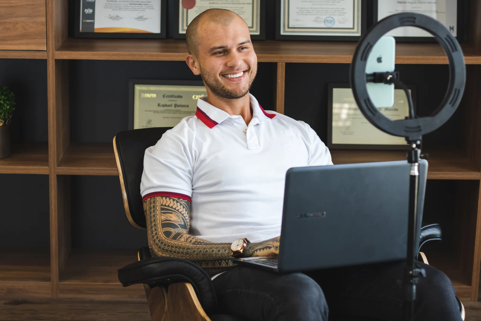 Raphael Polonis no consultório, diante do computador e de uma câmera para gravação